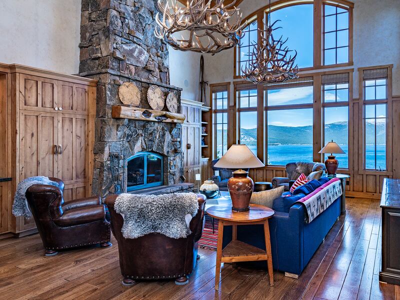 Lounge with wooden floors, high ceilings, large windows, and views of the water