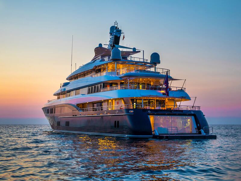 Yacht sailing towards setting sun
