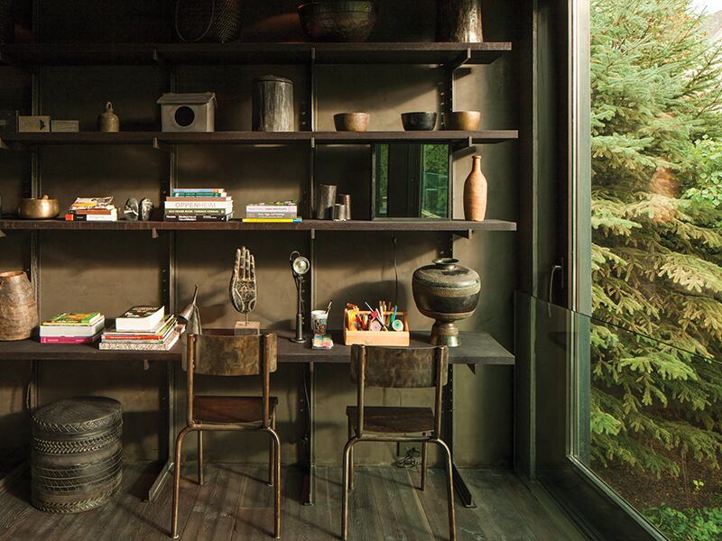 A workspace with shelves filled with items and large garden-facing window