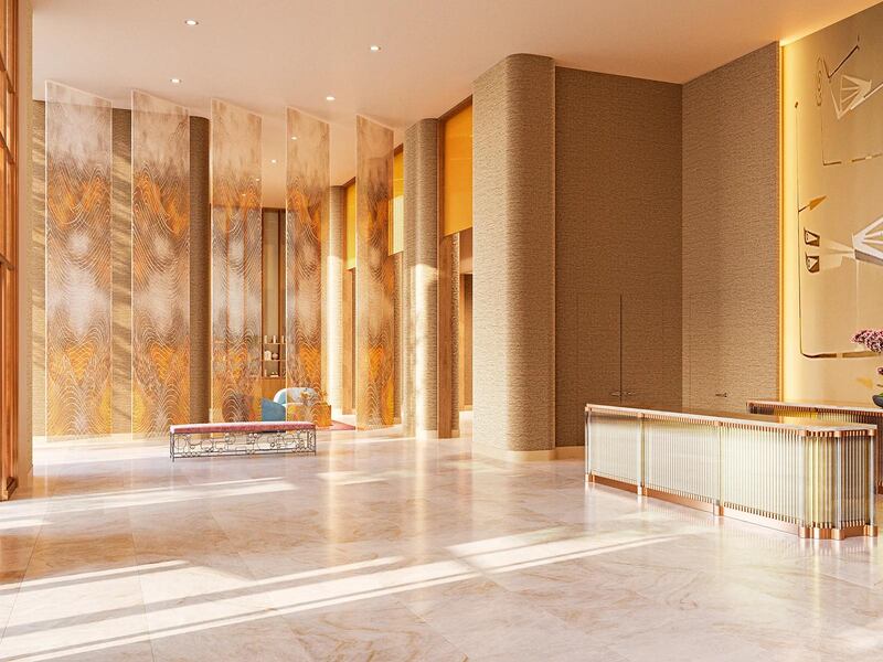 A golden-walled lobby with double-height ceilings and marble floors at The Atlantic Club.