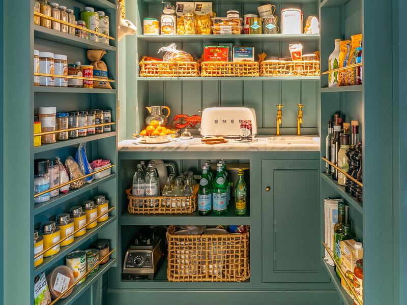 Open teal-coloured larder filled with food items and a toaster