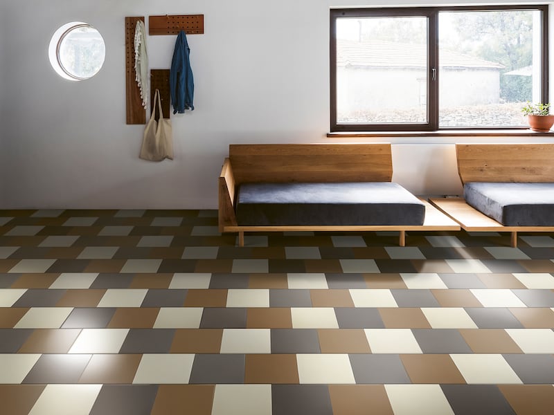 Grey, brown, and cream tiled floor set in a white room with wooden furniture