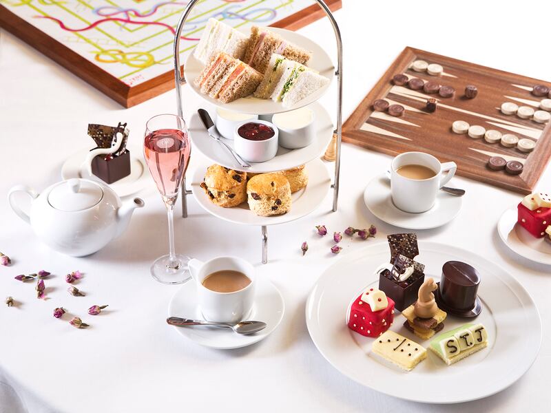 A close up of an afternoon tea with traditional board games on a white tablecloth