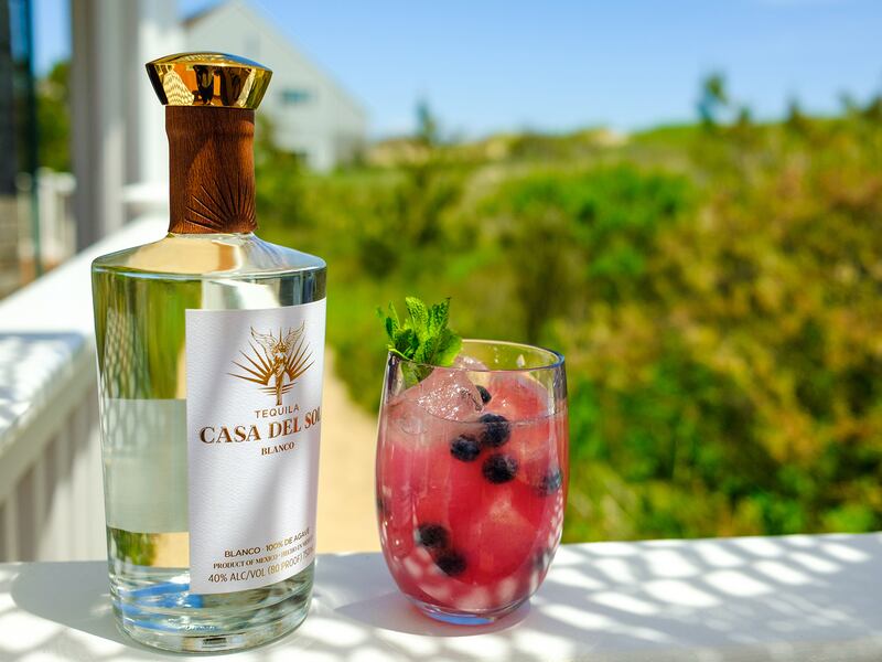 A bottle of Casa Del Sol tequila and a glass of tequila cocktail