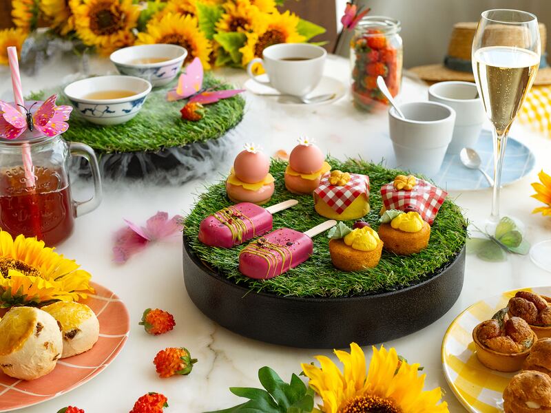 A spread of afternoon tea with a table decorated with sunflowers and strawberries