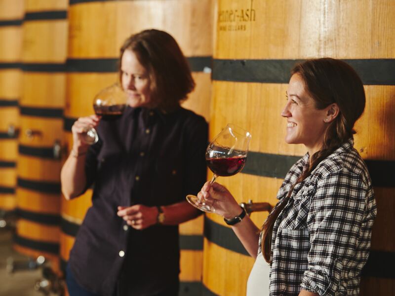 Women winemakers Lynn Penner-Ash and Kate Ayres sample wine in the cellar
