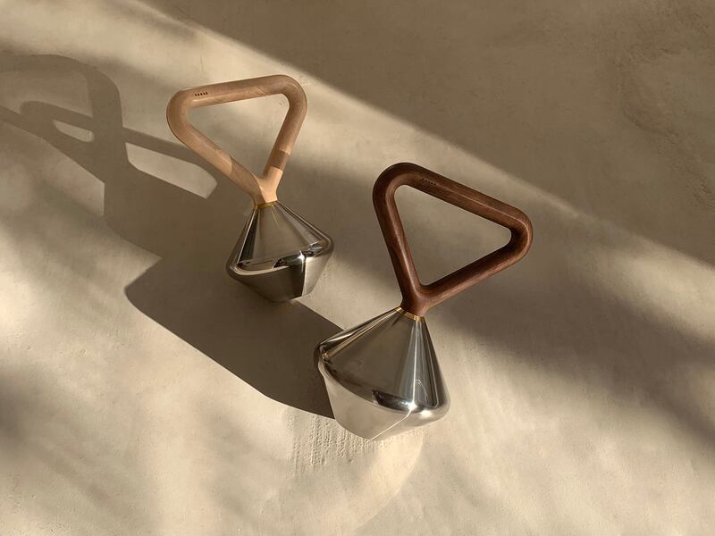 Two stainless steel kettlebells with walnut and maple handles