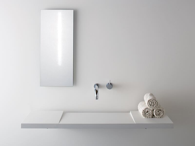 White minimalist modern sink with tap mounted into the wall